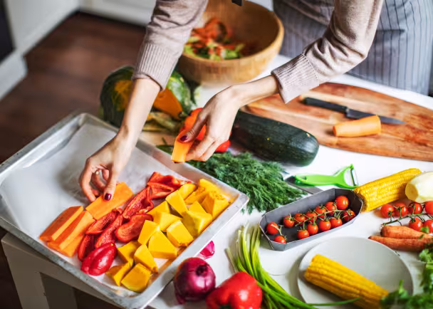 woman putting vegetables on tray