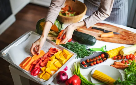 woman putting vegetables on tray