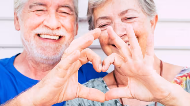 old couple making heart shape
