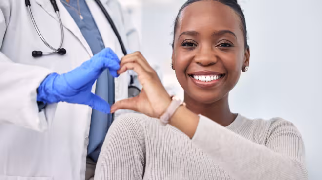 woman making heart in hands with doctor